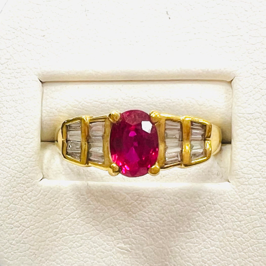 Anillo de Oro de 18 kilates Amarillo con un Rubí central Oval y brillantes a los lados